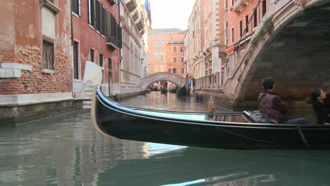 A-gondola-is-rowed-through-a-quiet-canal-in-Venice-Italy-1
