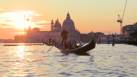 A-gondola-is-rowed-by-a-gondolier-in-front-of-the-setting-sun-in-romantic-Venice-Italy-1