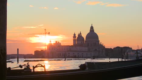 A-gondola-is-rowed-by-a-gondolier-in-front-of-the-setting-sun-in-romantic-Venice-Italy-3