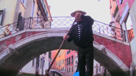 A-nice-shot-of-a-gondolier-rowing-a-gondola-under-a-bridge-in-Venice-Italy-1