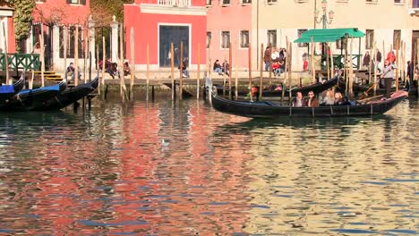 A-gondola-is-rowed-across-beautiful-colorful-water-in-Venice-Italy