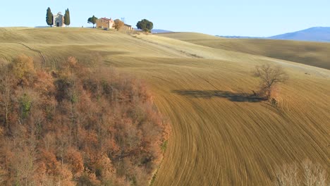 A-beautiful-farmhouse-and-church-in-the-distance-in-Tuscany-Italy