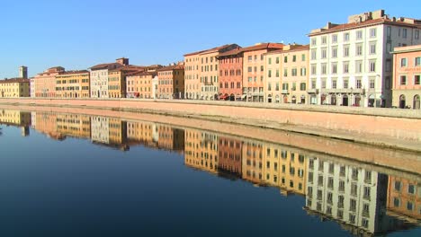 Buildings-line-and-are-reflected-in-a-symmetrical-canal-in-Pisa-Italy-2