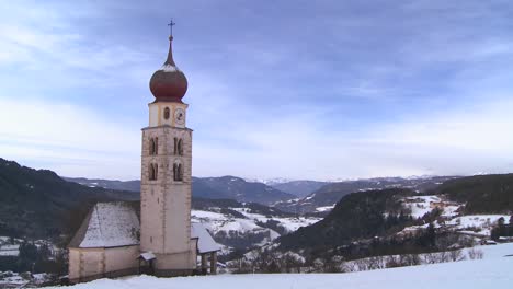 Time-lapse-clouds-over-an-Eastern-church-in-a-snowbound-Tyrolean-village-in-the-Alps-in-Austria-Switzerland-Italy-Slovenia-or-an-Eastern-European-country