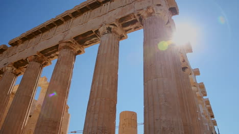Low-angle-pan-of-the-columns-of-the-Acropolis-and-Parthenon-on-the-hilltop-in-Athens-Greece