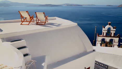 Pan-across-deck-chairs-sit-on-a-beautiful-balcony-in-the-Greek-Islands