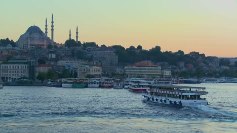 Boats-pass-in-the-harbor-in-front-of-the-mosques-of-Istanbul-Turkey-at-dusk