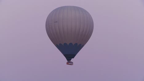 A-hot-air-balloon-flies-against-a-purple-sky