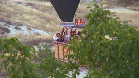 Passengers-ride-in-a-hot-air-balloon-that-is-almost-skimming-the-ground