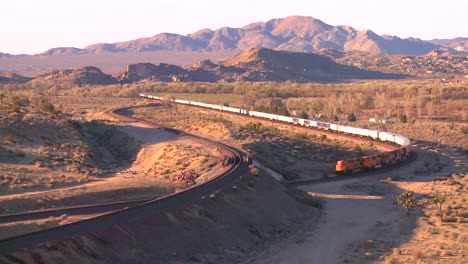 A-freight-train-moves-across-the-desert-from-a-high-angle