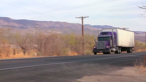 A-long-distance-truck-drives-on-a-road-through-the-desert