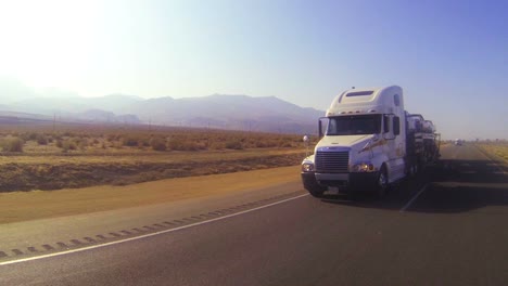 A-car-carrier-truck-moves-across-the-desert-in-this-POV-shot