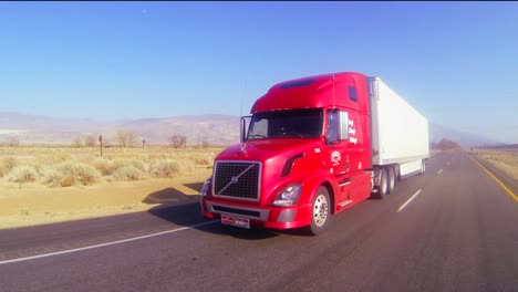 A-red-18-wheeler-truck-moves-across-the-desert-in-this-POV-shot
