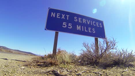 A-sign-on-a-lonely-desert-road-warns-that-the-next-services-are-55-miles-away