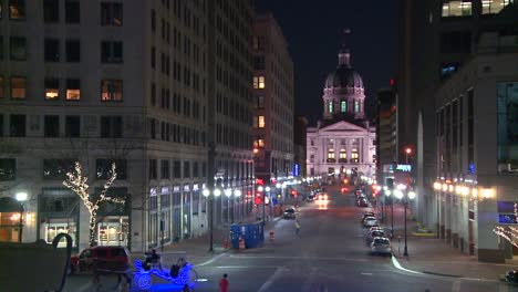A-horse-drawn-carriage-passes-the-Indiana-state-capital-building-in-Indianapolis-at-night