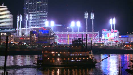 Light-reflects-off-the-Ohio-River-with-the-city-of-Cincinnati-Ohio-background-as-a-riverboat-passes-underneath-1