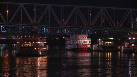 Light-reflects-off-the-Ohio-River-with-the-city-of-Cincinnati-Ohio-background-as-a-riverboat-passes-underneath-2