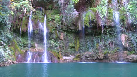 A-lush-and-fertile-tropical-waterfall-flows-into-a-green-pool