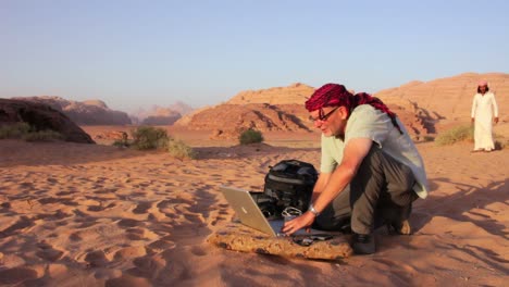 Ein-Mann-Arbeitet-An-Einem-Laptop-Mitten-In-Der-Wüste