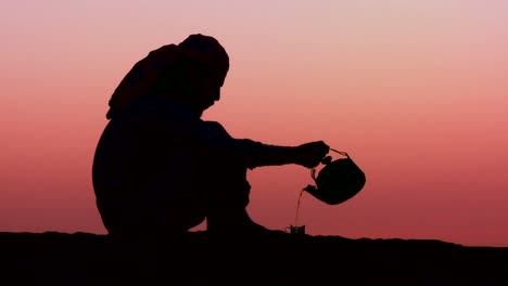 A-Bedouin-man-pours-tea-in-silhouette-against-the-sunset-2