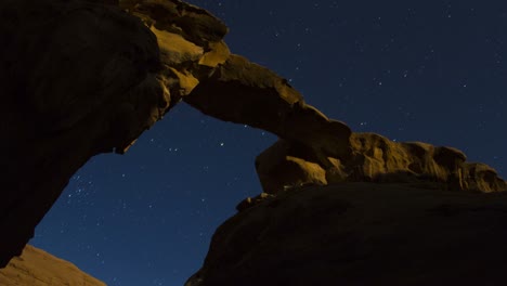 An-incredible-time-lapse-shot-looking-up-at-an-arch-formation-in-the-desert-against-a-night-sky
