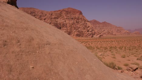 Die-Kamera-Bewegt-Sich-An-Einer-Sandsteinformation-Vorbei,-Um-Die-Riesige-Saudische-Wüste-Des-Wadi-Rum-Zu-Enthüllen