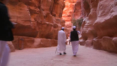 Los-Hombres-árabes-Caminan-Por-Los-Estrechos-Cañones-Que-Conducen-A-Petra-Jordan