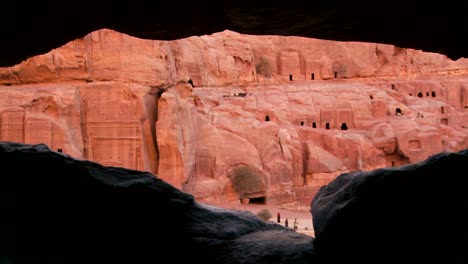 A-view-through-a-cave-frames-the-ancient-Nabatean-ruins-of-Petra-Jordan