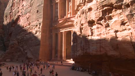 High-angle-tilt-up-view-of-the-facade-of-the-Treasury-building-in-the-ancient-Nabatean-ruins-of-Petra-Jordan-with-tourists