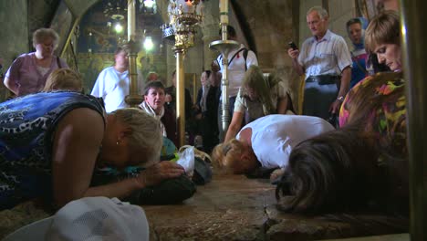 Christian-pilgrims-kneel-and-kiss-the-stone-where-Jesus-was-taken-from-the-cross-in-the-Holy-Sepulcher-in-Jerusalem-Israel-1