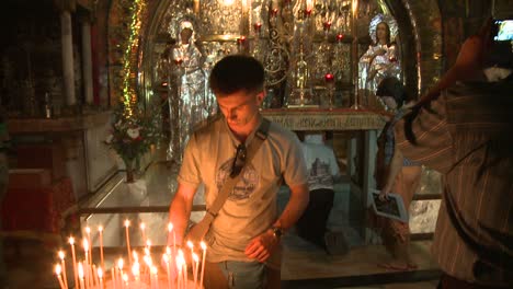 A-young-boy-lights-a-candle-in-the-Holy-Sepulcher-in-Jerusalem-Israel