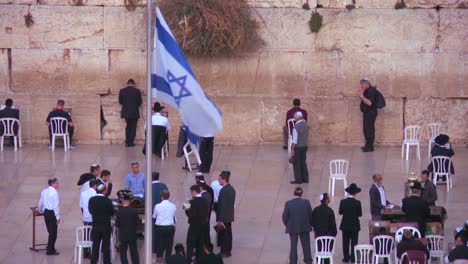 The-Israeli-flag-waves-in-front-of-Jewish-pilgrims-praying-at-the-Wailing-Wall-in-Jerusalem-Israel