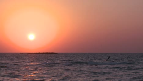 A-windsurfer-moves-along-a-coastline-at-sunset-2