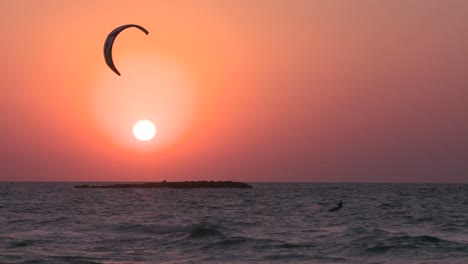 A-windsurfer-moves-along-a-coastline-at-sunset-4