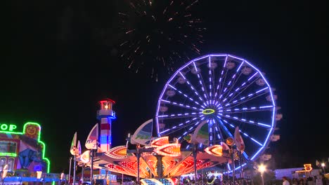 Fireworks-explode-in-the-night-sky-behind-a-ferris-wheel-at-a-carnival-or-state-fair-1