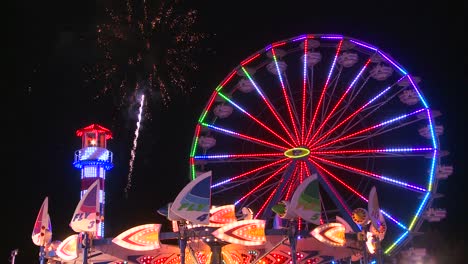 Fireworks-explode-in-the-night-sky-behind-a-ferris-wheel-at-a-carnival-or-state-fair-2