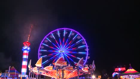 Fireworks-explode-in-the-night-sky-behind-a-ferris-wheel-at-a-carnival-or-state-fair-4