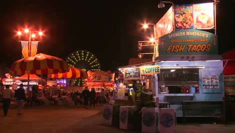 Establishing-shot-of-an-amusement-park-carnival-or-state-fair-at-night-