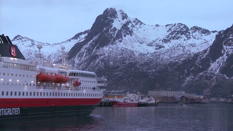 The-cruise-ship-Hurtigruten-sails-through-the-fjords-of-Norway-to-arrive-at-Svolvaer-in-the-Lofoten-Islands