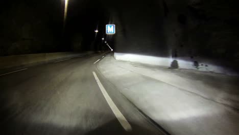 POV-shot-of-a-car-traveling-through-a-single-lane-tunnel-through-a-mountain
