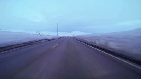 POV-shot-of-a-car-traveling-at-high-speed-along-a-mountain-road-with-ice-and-snow-1