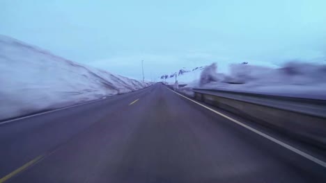 POV-shot-of-a-car-traveling-at-high-speed-along-a-mountain-road-with-ice-and-snow-2