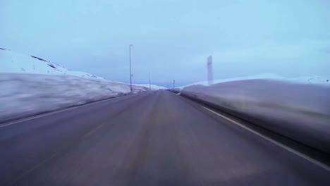 POV-shot-of-a-car-traveling-at-high-speed-along-a-mountain-road-with-ice-and-snow-3