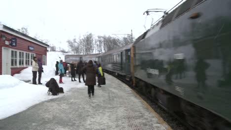 A-train-arrives-at-a-snowy-mountain-station-in-Norway