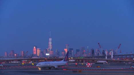 Flugzeuge-Taxi-Am-Flughafen-Newark-In-Der-Abenddämmerung-Mit-Manhattan-Skyline-Hintergrund-1
