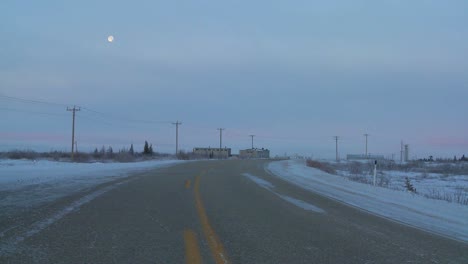 The-moon-rises-behind-a-frozen-highway-across-the-tundra