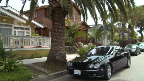 A-black-Mercedes-pulls-up-to-the-curb-on-a-California-or-Florida-street