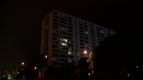 Kippen-Sie-Nachts-Zu-Einem-Allgemein-Aussehenden-Bürogebäude-Oder-Hotel-Mit-Verkehrsvordergrund