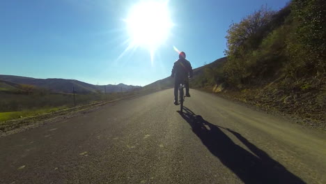 Un-Hombre-Monta-Una-Bicicleta-Motorizada-Por-El-Campo-En-Una-Carretera-De-Dos-Carriles-3