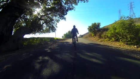 Un-Hombre-Monta-Una-Bicicleta-Motorizada-Por-El-Campo-En-Una-Carretera-De-Dos-Carriles-5